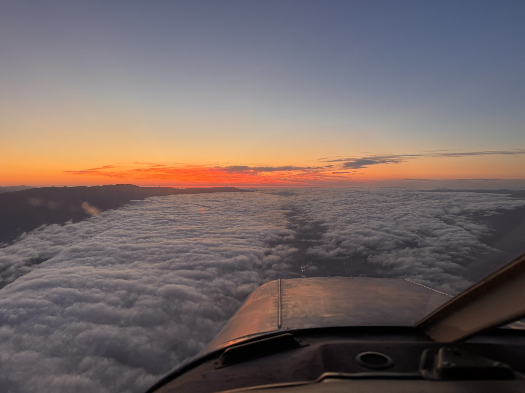 Golden-hour view over the clouds from the cockpit