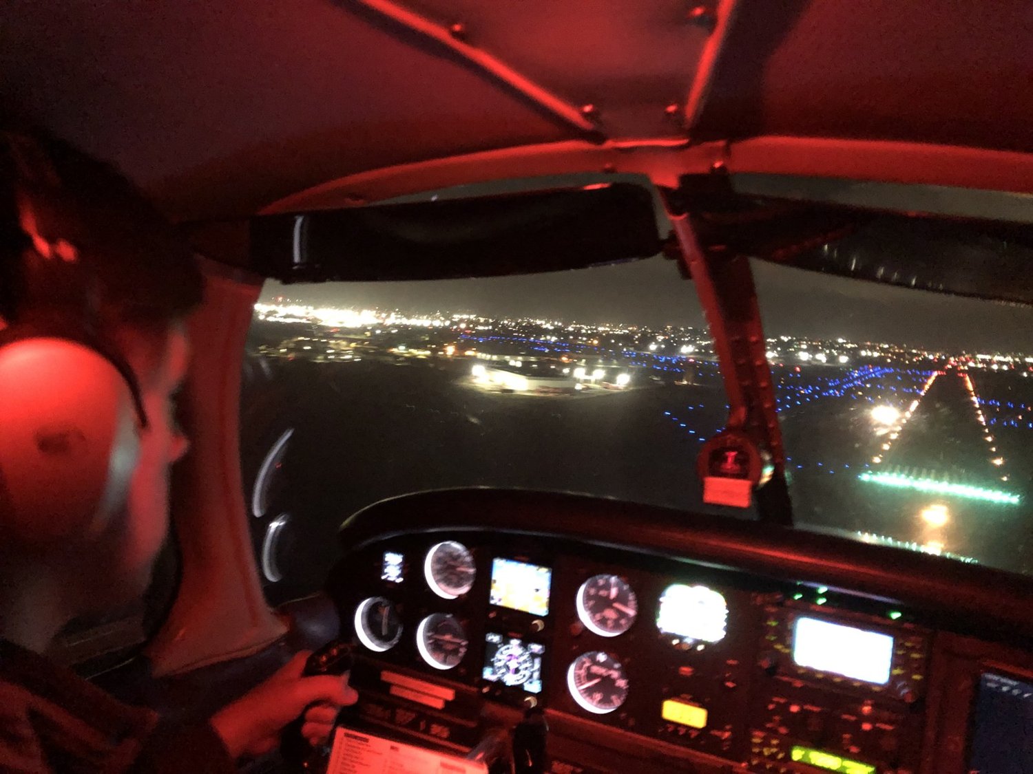 Night cockpit view with city lights below