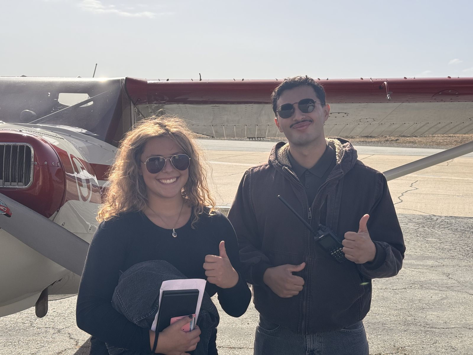 Hadley and her instructor Gabriel Barajas giving a thumbs up in front of the Luscombe.