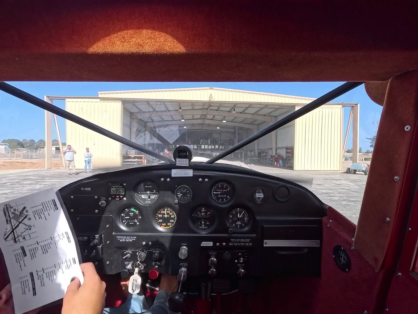 Cockpit view at the hangar after landing, with the shutdown checklist in hand.