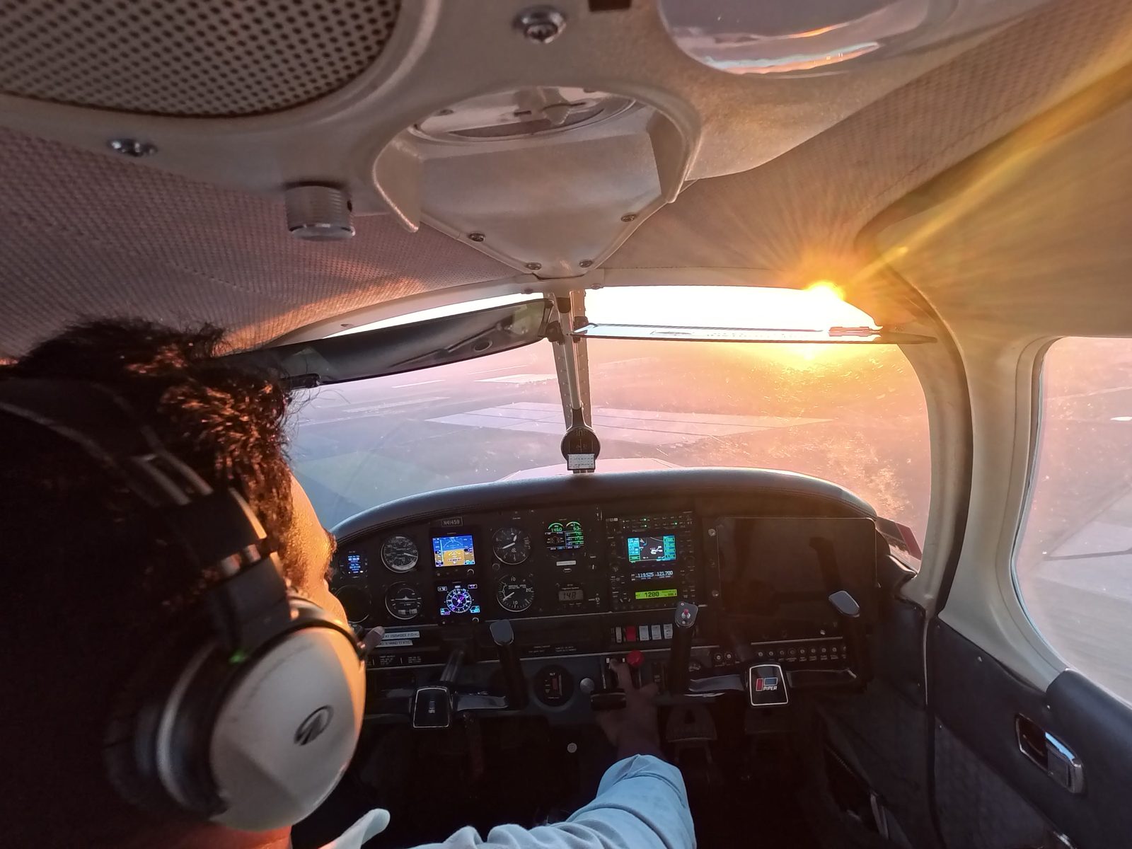 The sun setting ahead of the Warrior's windshield as Nazeem flies the pattern.